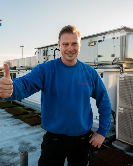 Servicetechniker der GK Fullservice an einer Lüftungsanlage auf dem Dach